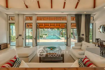 Luxurious living room with pool view, elegant decor, and spacious seating area in a modern home.