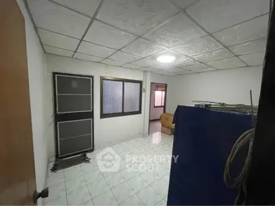 Spacious room with tiled flooring and ceiling lights, ideal for versatile use.