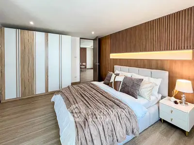 Luxurious modern bedroom with elegant wood paneling and plush bedding