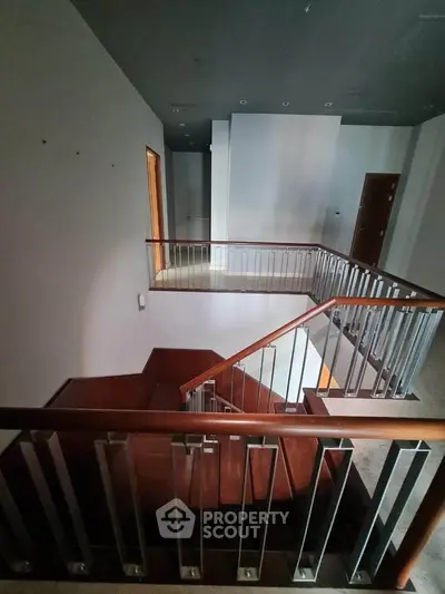Modern staircase with sleek metal railings and wooden steps in a contemporary home.