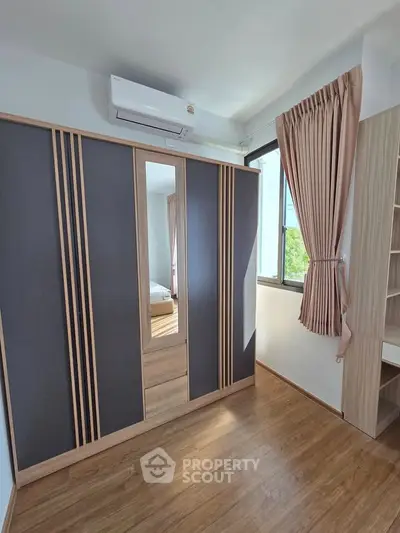 Modern bedroom with sleek wardrobe and natural light from large window