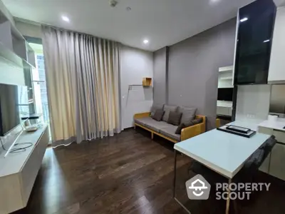 Modern living room with sleek furniture and dark wood flooring in a stylish apartment.