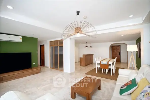 Spacious modern living room with dining area, featuring stylish furniture and elegant lighting.
