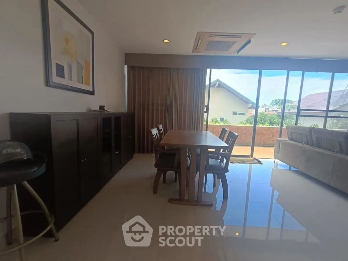 Spacious living room with large windows and modern furniture, offering a bright and airy atmosphere.