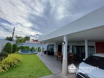 Spacious modern home with pool and lush garden, perfect for outdoor living.