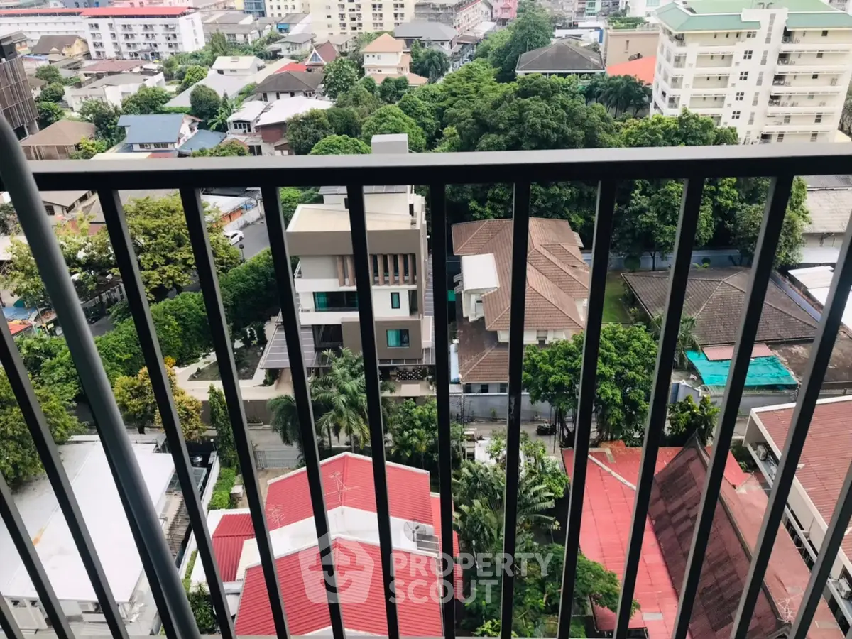 Stunning cityscape view from a high-rise balcony overlooking lush greenery and urban landscape.