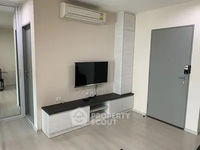 Modern living room with sleek TV unit and air conditioning in a stylish apartment.