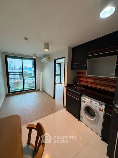 Modern apartment with city view, open layout kitchen, and washing machine.