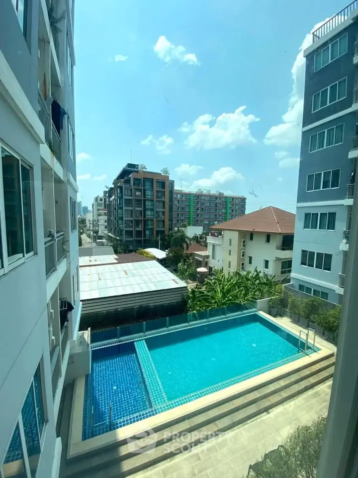 Stunning urban view with a sparkling pool and modern buildings under a clear blue sky.