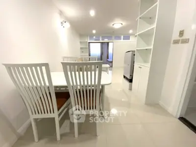 Modern dining area with sleek white furniture and open layout