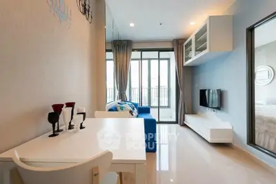 Modern living room with sleek design and large windows opening to balcony.