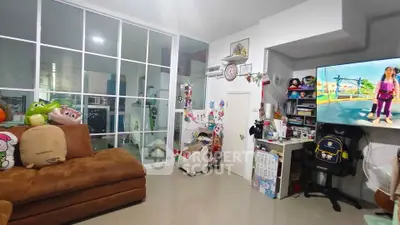 Cozy living room with plush sofa, glass partition, and entertainment setup in modern home.