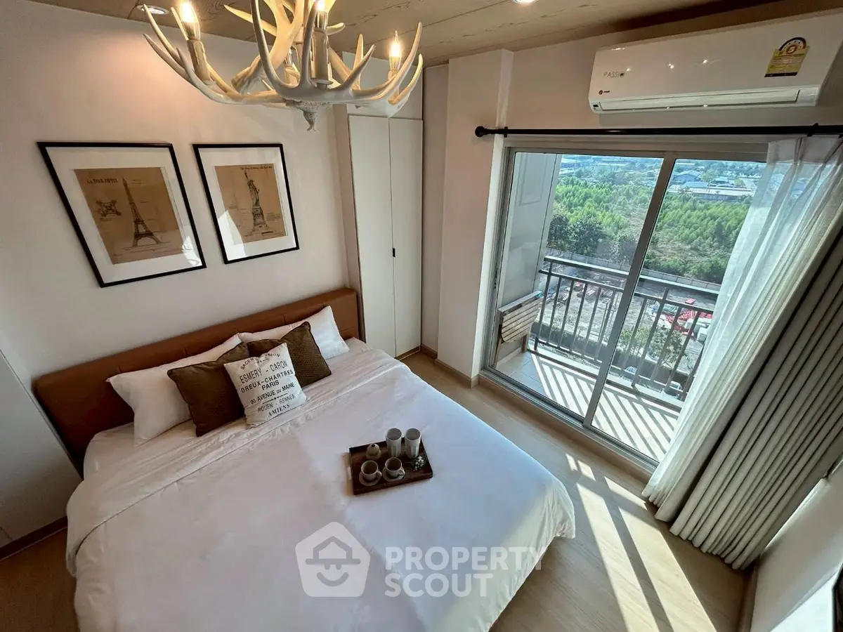 Chic bedroom with balcony view, modern decor, and natural light in a stylish apartment.