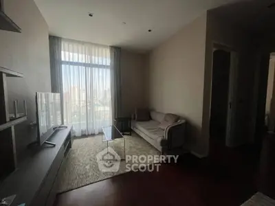 Cozy living room with modern decor and large window offering city views.