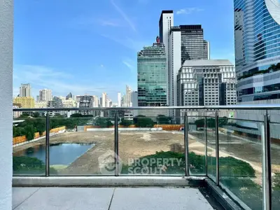 Stunning cityscape view from a modern balcony with glass railing, perfect for urban living.
