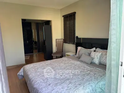 Spacious bedroom with elegant decor and natural light, featuring a comfortable bed and stylish furnishings.