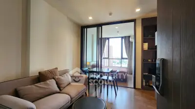 Modern living room with cozy sofa and dining area, featuring a view of the city skyline through large windows.
