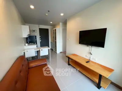 Modern living room with sleek furniture and wall-mounted TV in a stylish apartment.