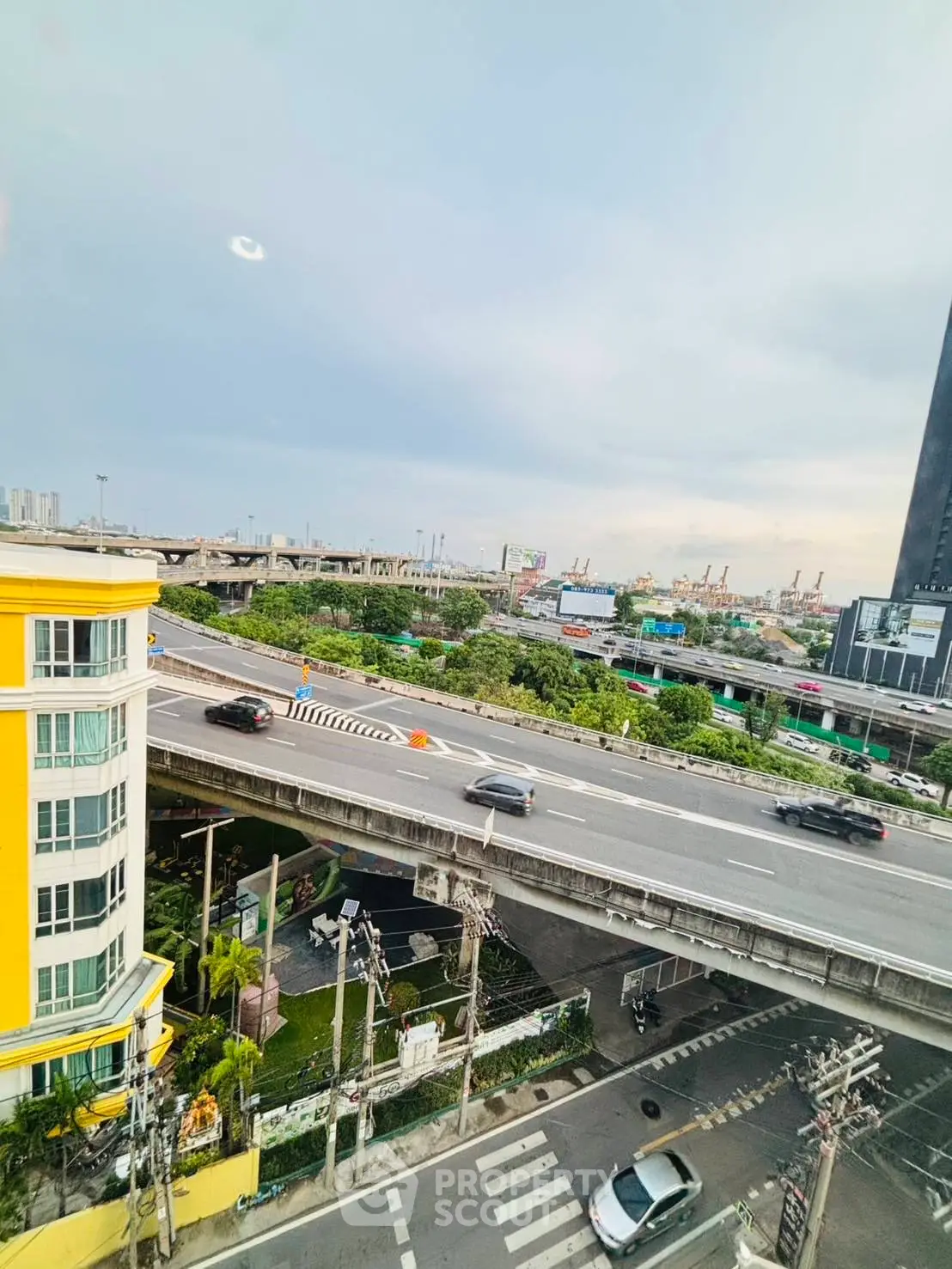 Stunning urban view from high-rise building overlooking highway and cityscape.