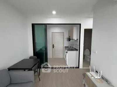 Modern apartment interior with compact kitchen and living area, featuring sleek design and efficient use of space.