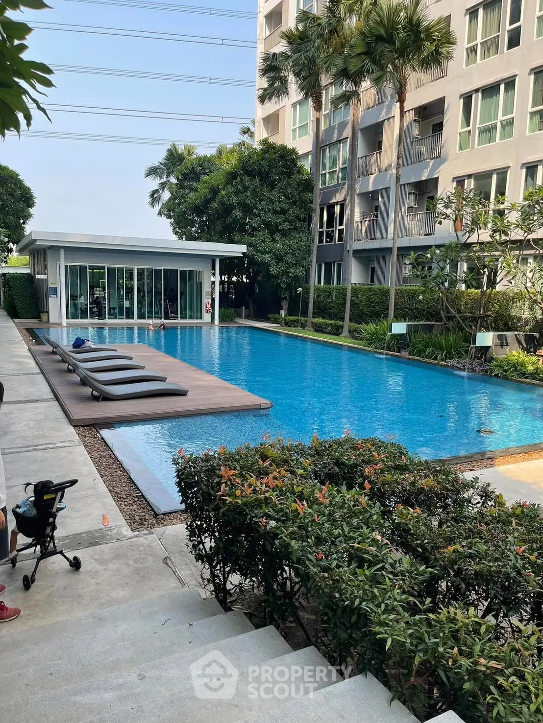 Luxurious condominium with a stunning outdoor pool and lush greenery, perfect for relaxation and leisure.