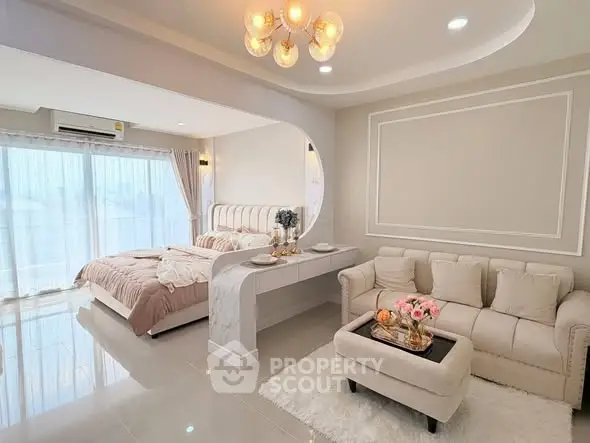 Luxurious open-plan bedroom and living area with elegant decor and natural light.
