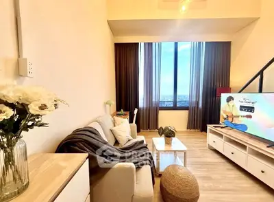Charming living room with cozy decor and large window offering stunning city views.