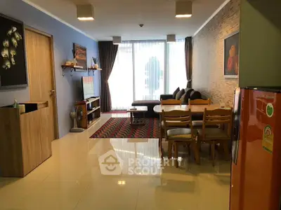 Spacious living room with modern decor and natural light, featuring a cozy dining area and stylish furniture.