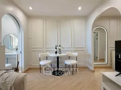 Elegant living room with modern decor and stylish arches, featuring a cozy seating area and chic lighting.