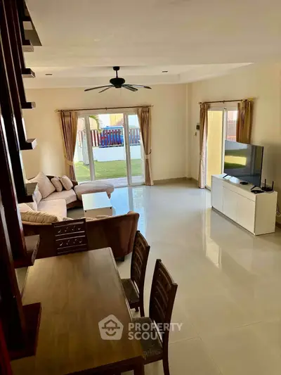 Spacious living room with modern furniture and garden view, perfect for family gatherings.