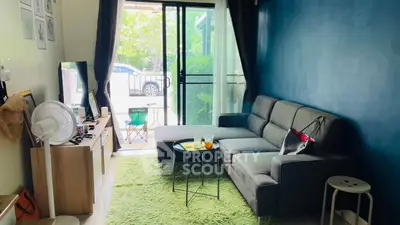 Cozy living room with modern sofa and natural light, perfect for relaxation.
