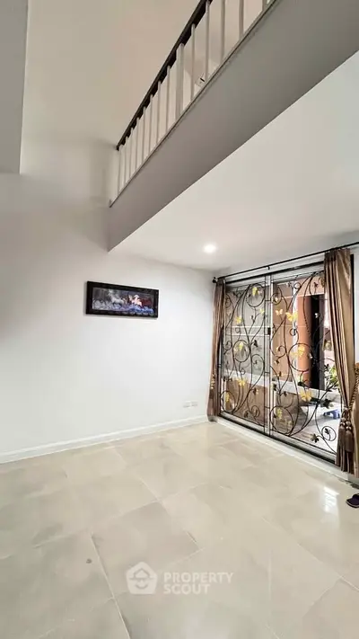 Spacious living room with elegant ironwork window and high ceiling