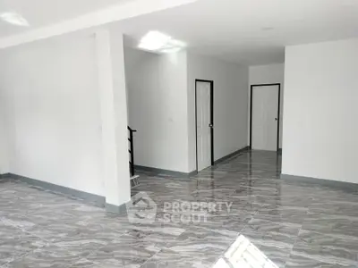 Spacious modern interior with glossy marble flooring and white walls, ideal for customization.