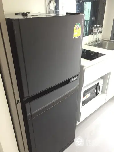 Modern kitchen with sleek black refrigerator and built-in microwave