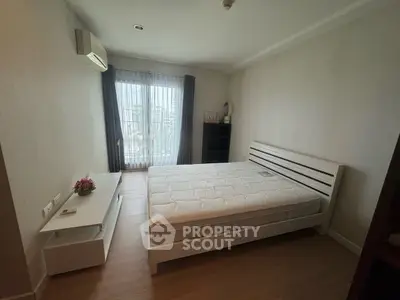 Spacious bedroom with natural light and modern furnishings in a cozy apartment.