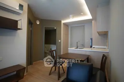 Modern compact living room with dining area and open kitchen in stylish apartment.