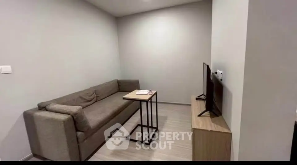 Modern living room with cozy sofa and sleek TV setup, perfect for relaxation and entertainment.