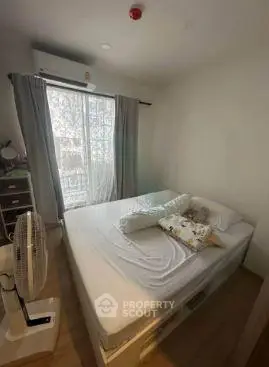 Cozy bedroom with natural light and simple decor, perfect for relaxation.