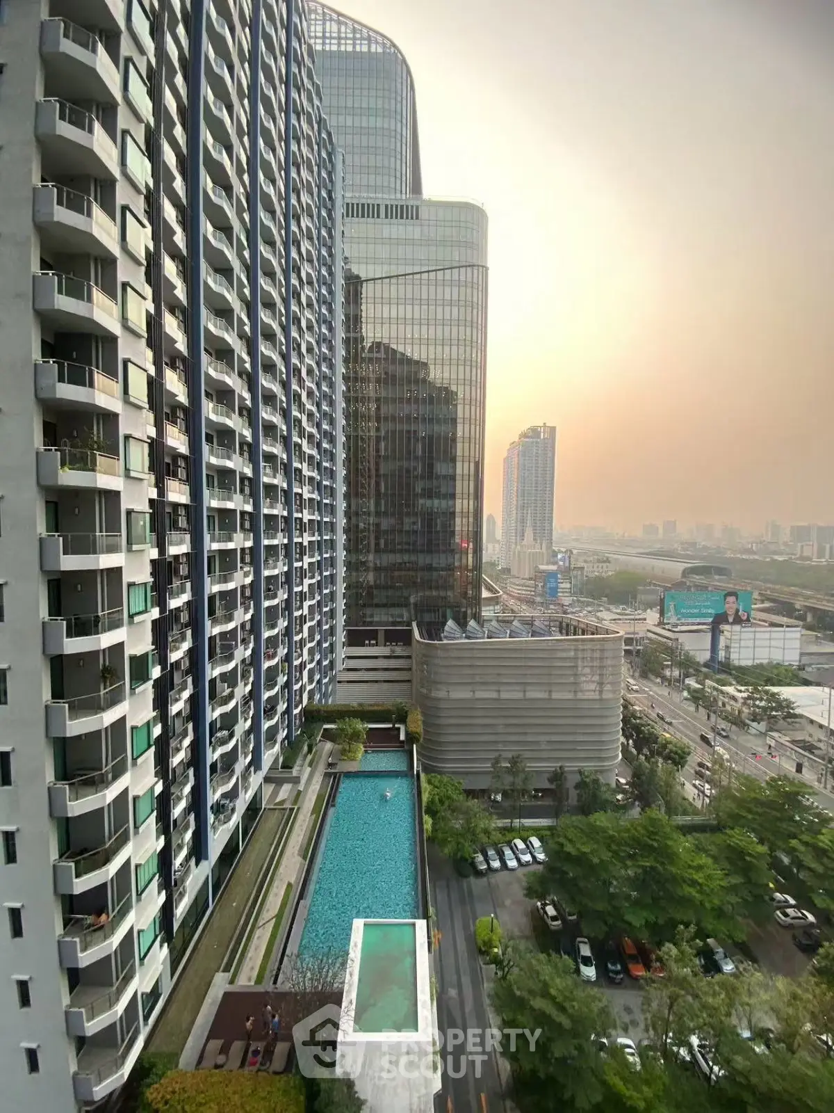 Stunning high-rise building with pool and cityscape view at sunset, perfect for urban living.