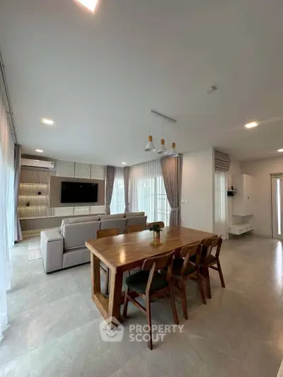 Spacious modern living room with elegant dining area and natural light.