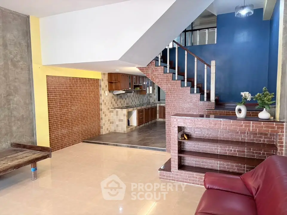 Spacious living room with modern staircase and open kitchen layout