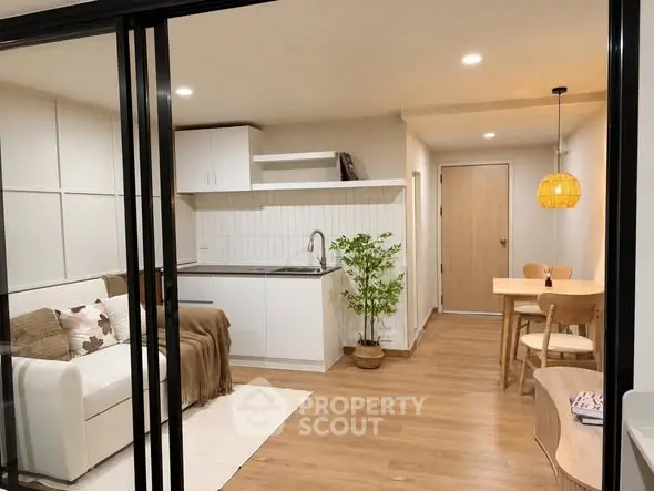 Modern open-plan living room and kitchen with stylish decor and warm lighting