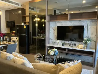 Luxurious modern living room with open kitchen, featuring elegant decor and high-end appliances.