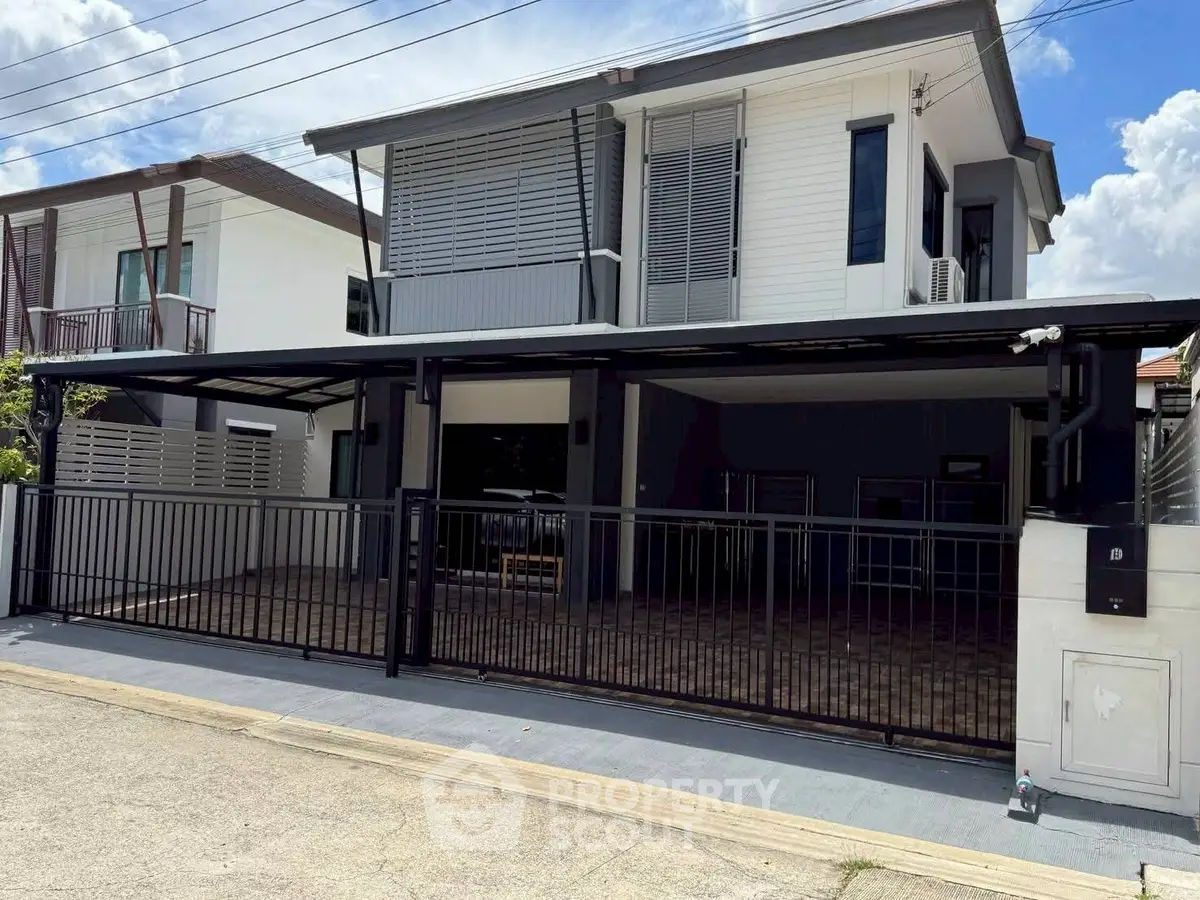 Modern two-story house with sleek design and spacious driveway in a suburban neighborhood.