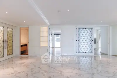 Luxurious marble-floored living room with elegant glass doors and ample natural light.
