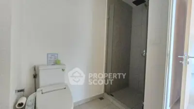 Modern bathroom with sleek shower and toilet in minimalist design.