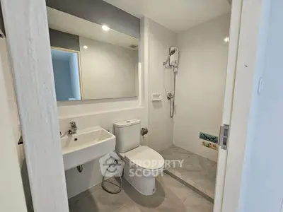 Modern bathroom with sleek fixtures and walk-in shower in a contemporary apartment.