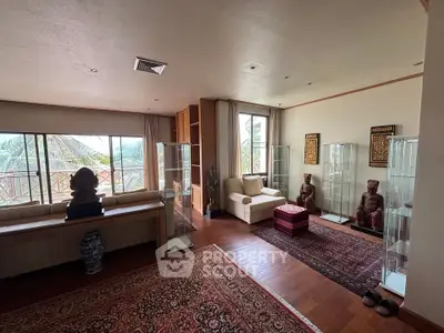 Spacious living room with elegant decor and large windows offering a serene view.