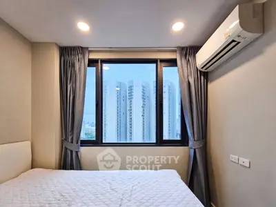 Modern bedroom with city view, featuring large window and air conditioning unit.