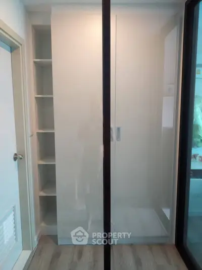 Modern storage space with sleek sliding doors and built-in shelves, perfect for organized living.